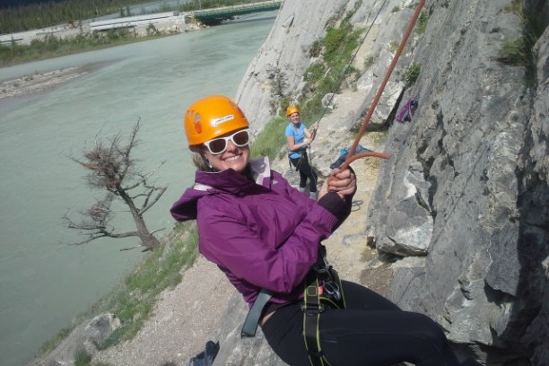 Rock climber balaying down rock face