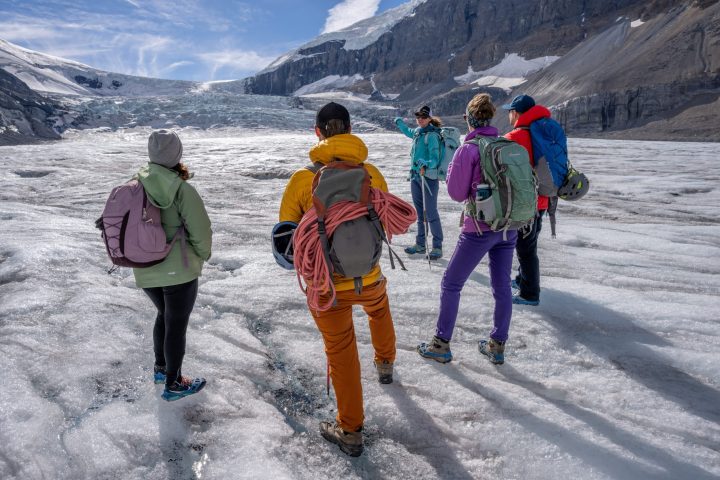 a group of people standing on top of a snow covered mountain