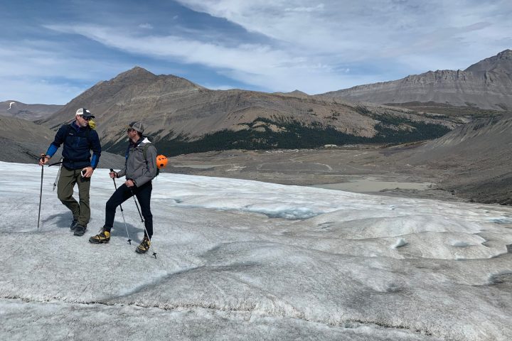 a man riding skis down a snow covered mountain