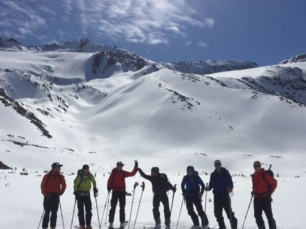A group of skiers on a snow covered mountain during their Robson Valley AST1 course
